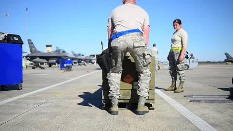 Crew unpacking munitions from box for building and loading program with F-16 Stock Footage 83308142