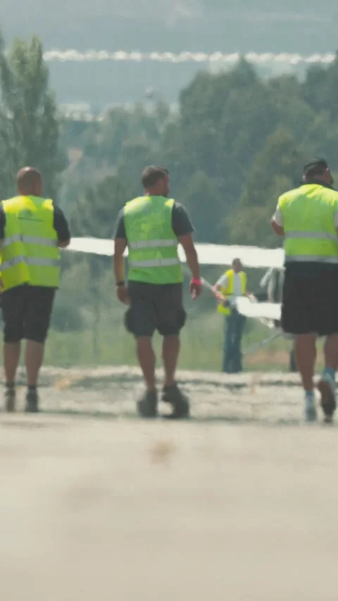 Crew walks towards construction site on a sunny day at local festival grounds Stock Footage 338242688