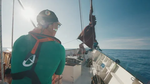 Crew work with the sails on the big expeditional sailing vessel moving in the Stock Footage 340203301