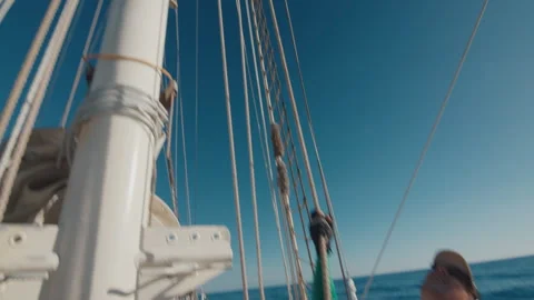 Crew work with the sails on the big expeditional sailing vessel moving in the Stock Footage 343347439