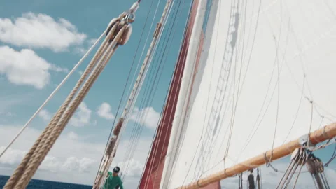 Crew work with the sails on the big expeditional sailing vessel moving in the Stock Footage 344968273