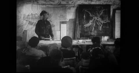 Crews being briefed by military officer for a raid in briefing room Stock Footage