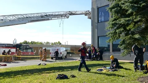 Crews packing up after high-angle rope rescue while paramedics help man Stockbeeldmateriaal 95913136