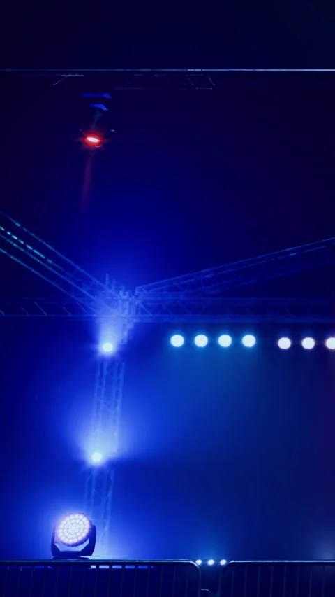 Crews work on the lighting setup for a performance at night Stock Footage 330163242