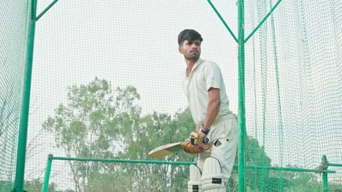 Cricket player facing the ball in net practice. Right hand batsman hits ball. Vidéo 251644360
