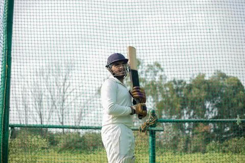 Cricket player is ready to practice batting in the nets during his practice time Stock Photos
