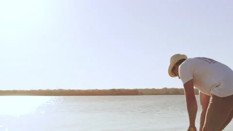 Cricket player striking ball on the beach with lake and sky in the background in Stock Footage 199458261
