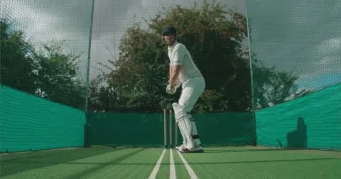 Cricketer plays shot towards camera in nets. Vídeo Stock 58837471