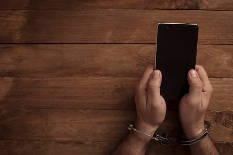 Crime concept in the network using a smartphone. Stock Photos