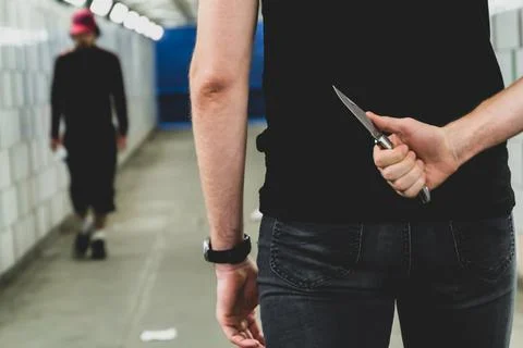 Crime robbery concepts. A robber hiding his sharp knife at a person to rob her Stock Photos