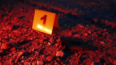 Crime scene evidence marker next to bullet shells with flashing police lights Video stock 337870812