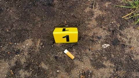 Crime scene evidence marker next to a cigarette butt Stock Footage 338327428