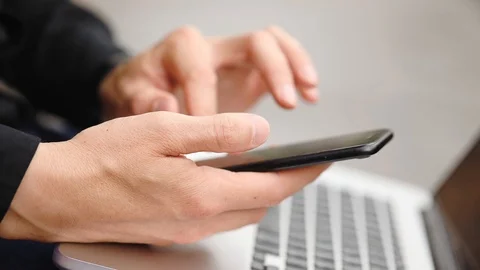 Criminal in black does break-in with smartphone and laptop Stock Footage 111611477