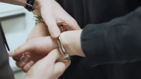 Criminal gets handcuffed by police while booked in jail. Stock Footage