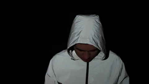 A criminal guy with a lowered head looks down, police flashers on his face Video stock 150787445