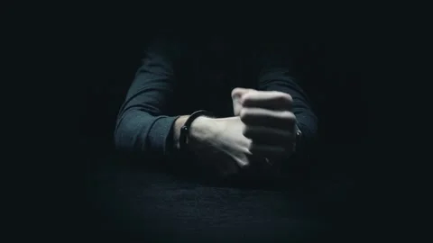 The criminal in handcuffs sits at the table. Stock Footage 144441399