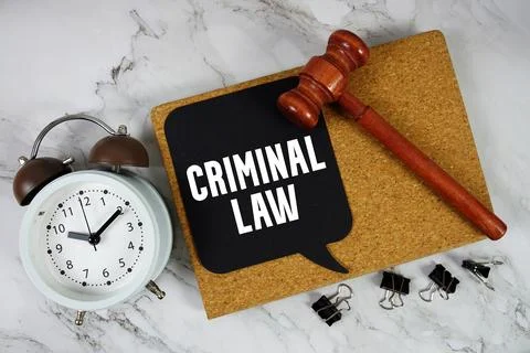 Criminal Law text on speech bubble with alarm clock and wooden gavel on mar.. Stock Photos