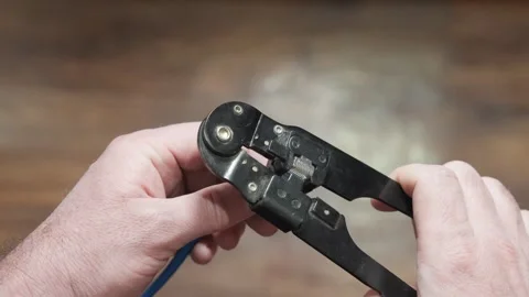 Crimping connector on internet cable, hand of craftsman with tool, close-up. Stock Footage 262759100