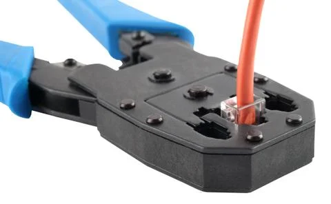 Crimping tool with a network cable isolated on white background. Stock Photos