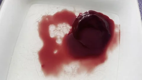 Crimson Cascade: A Closeup of Red Liquid Drops on a White Background Stock Footage 245743888