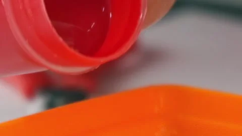 Crimson Cascade Into an Orange Craft Tray Stock Footage 340594199