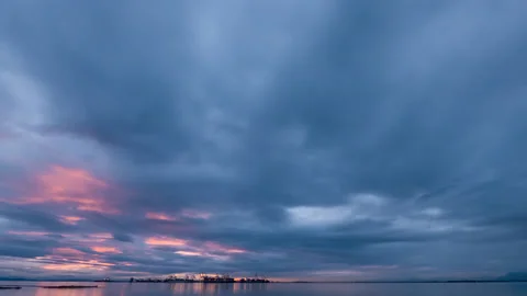 Crimson sunset and thick clouds over the ocean and seaport Stock Footage 139733201