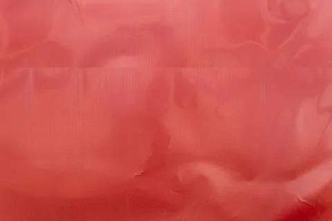 Crinkled red plastic wrap texture with glossy highlights and folds plastic .. Stock Photos