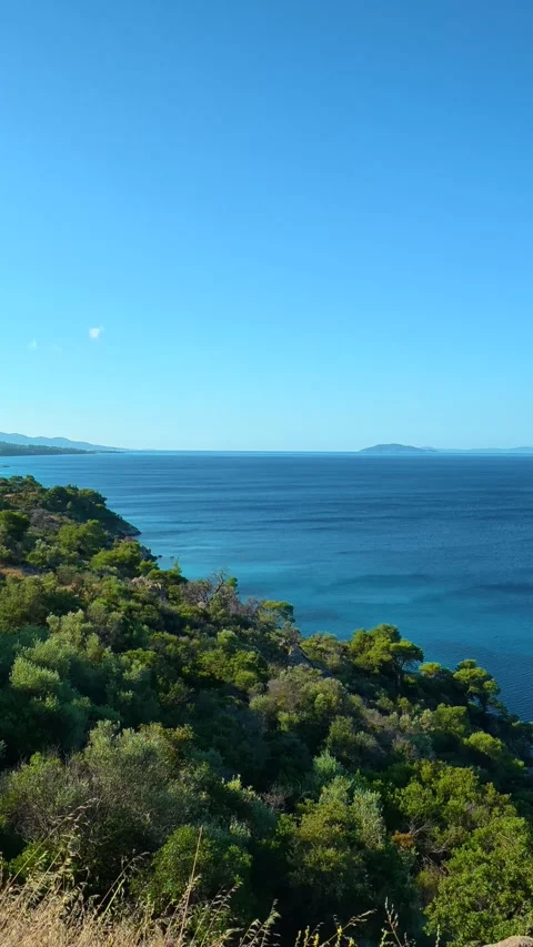 Crisp blue sky above turquoise waters. Lagomandra, Greece. Vertical Stock Footage 339623964