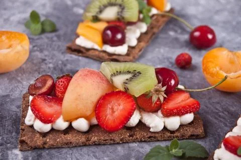Crisp bread with creme cheese, fruit and berries Stock Photos