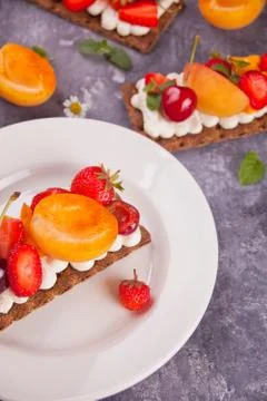 Crisp bread with creme cheese, fruit and berries Photos