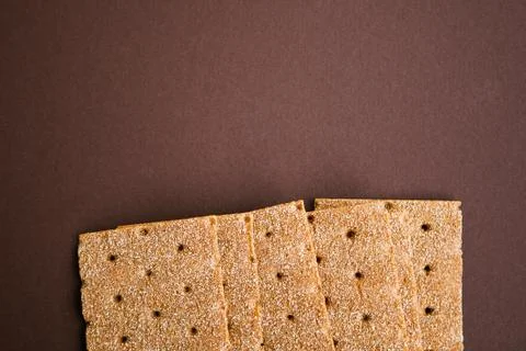Crisp bread on the dark brown background. Corn dodger. Crackers. Loaf of brea Stock Photos