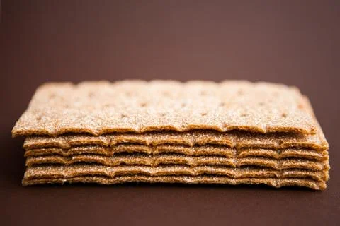 Crisp bread on the dark brown background. Corn dodger. Crackers. Loaf of brea Stock Photos