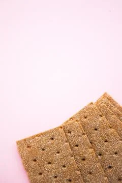 Crisp bread on the pink background. Corn dodger. Crackers. Loaf of bread. Foto stock