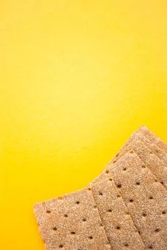 Crisp bread on the yellow background. Corn dodger. Crackers. Loaf of bread. Stock Photos