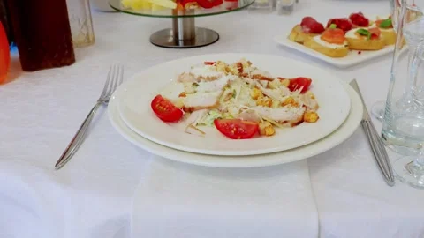 Crisp caesar salad with grilled chicken breast, cherry tomatoes, parmesan, and Stock Footage 327218340
