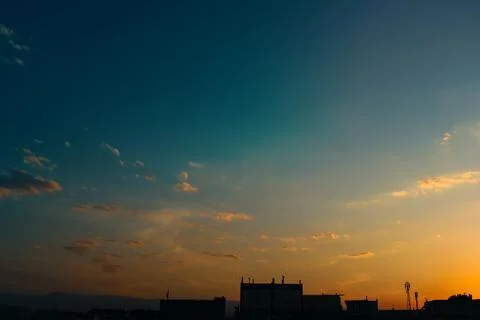 A crisp evening sky with soft gradient from blue to golden orange and silhouette Stock Photos