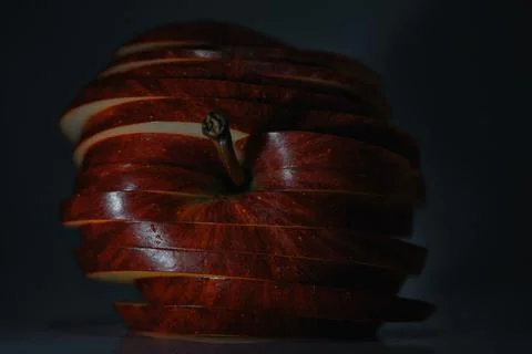 Crisp layered fruit composition, closeup of glossy apple slices under dramatic Stock Photos