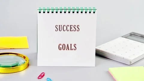 A crisp notebook detailing success goals stands prominently on a light grey Stock Footage 331500510