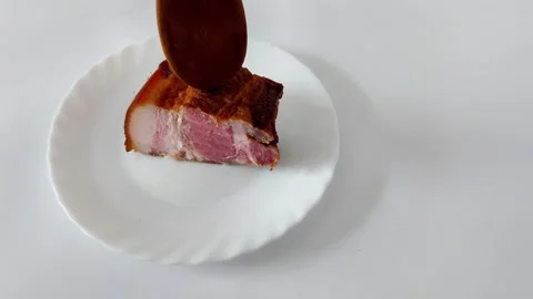 Crisp-Skinned Pork Belly Presented on White Ceramic Plate Video stock 320859239