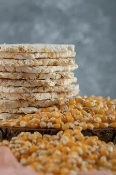 Crispbread and raw corn seeds on wood piece Stock Photos