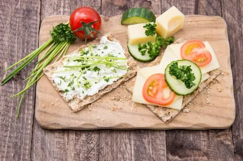 Crispbread with cheese on a board Stock Photos