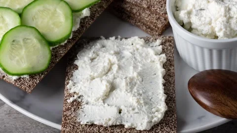 Crispbreads with cottage cheese and cucumber slices Stock Footage 297787729