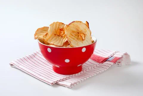 Crispy apple chips in a red bowl Stock Photos