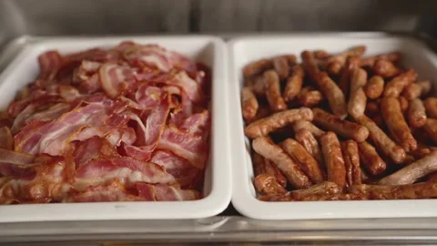 Crispy bacon and sausages in buffet serving trays Stock Footage 341166252