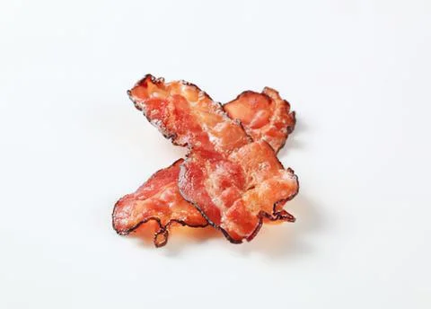 Crispy bacon pieces arranged on plain background Stock Photos