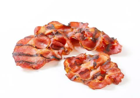 Crispy bacon pieces on white background Stock Photos