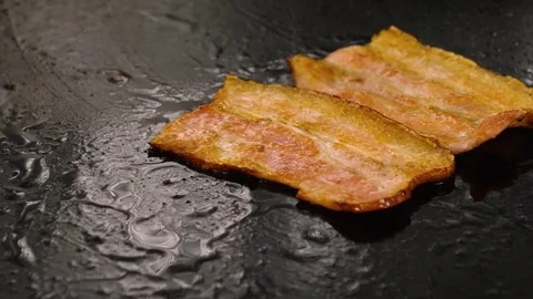 Crispy bacon rashers sizzling on the grill Stock Footage 76952485