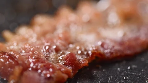 Crispy bacon sizzling in a pan, close-up shot. Stock Footage 317451653