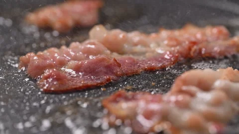 Crispy bacon sizzling in a pan, close-up shot. Stock Footage 317451970