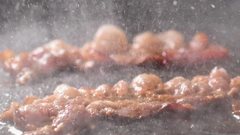 Crispy bacon sizzling in a pan, close-up shot. Stock Footage 317452004